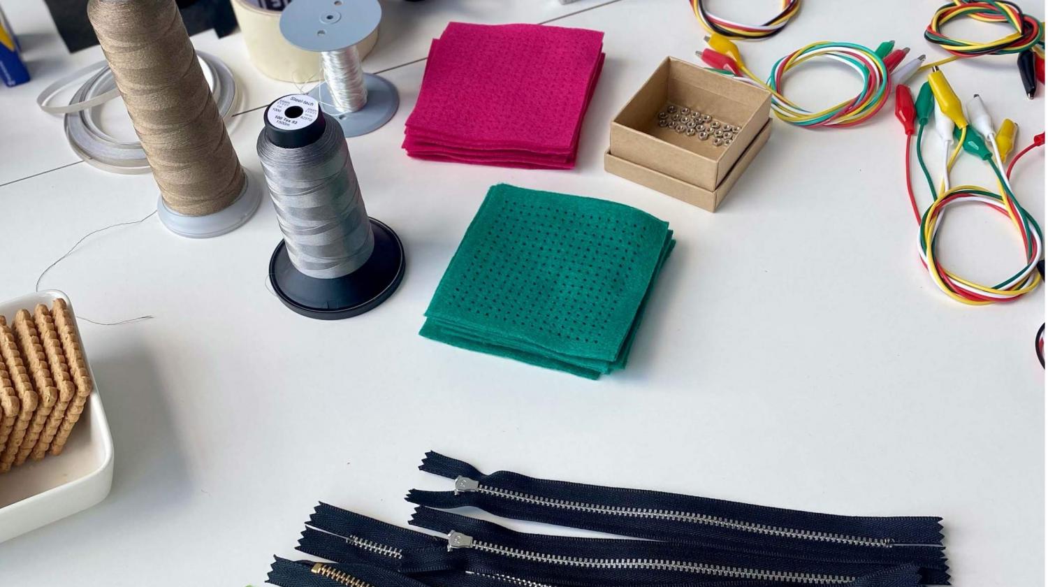 Tools, fabrics, and zippers displayed on the lab table.
